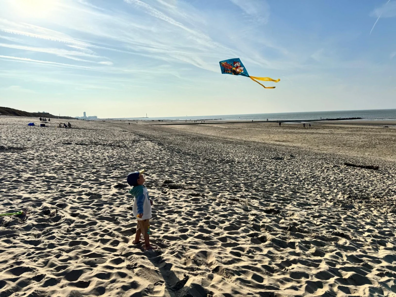 Kind op het strand met een vlieger
